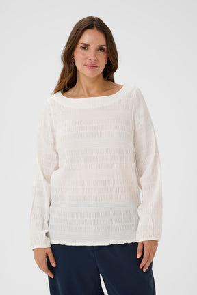 Woman wearing a Kaffe Curve Jourtney Blouse in White on a plain background