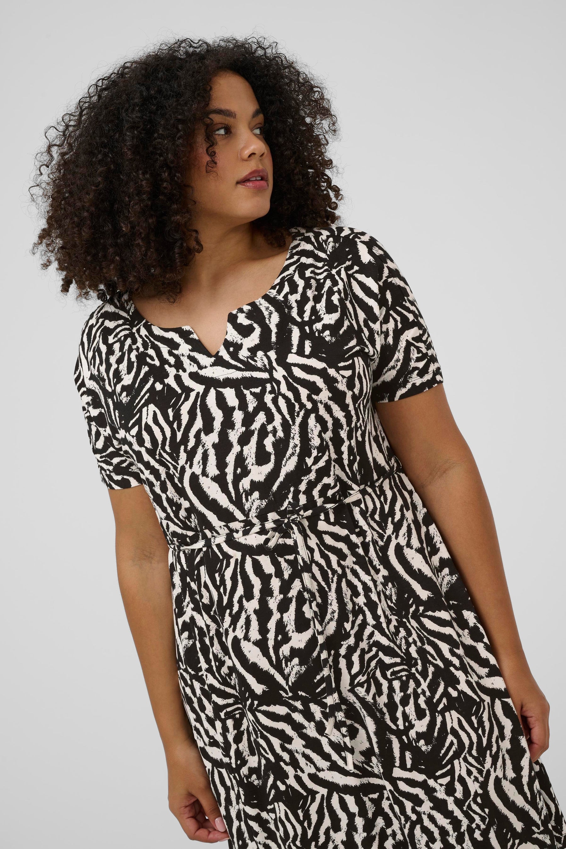 Kaffe Curve Mella Dress in Black, short sleeves, all over animal print,removable tie belt at the waist and a rounded V neckline