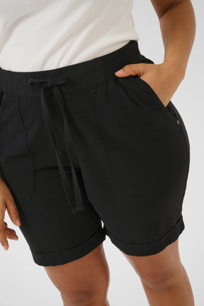 Black knee length shorts with a drawstring in the elasticated waist, side pockets and turn ups at the end, worn by a person on a plain background