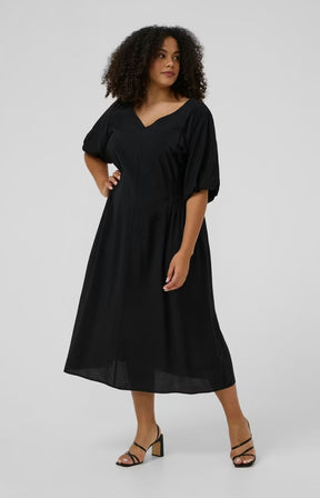 Kaffe Curve Neela Dress in Black with a V neckline, 1/2 length puff sleeves, waist elasticated and falls to a midi length, mid calf 
