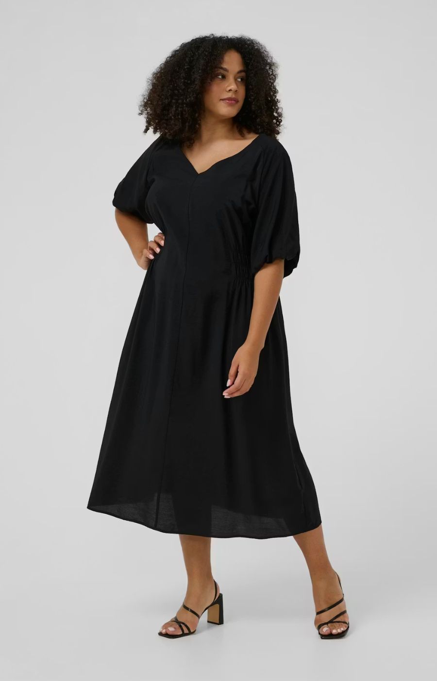 Kaffe Curve Neela Dress in Black with a V neckline, 1/2 length puff sleeves, waist elasticated and falls to a midi length, mid calf 