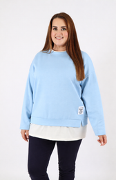 Woman wearing a blue sweatshirt with a white trim on a plain background