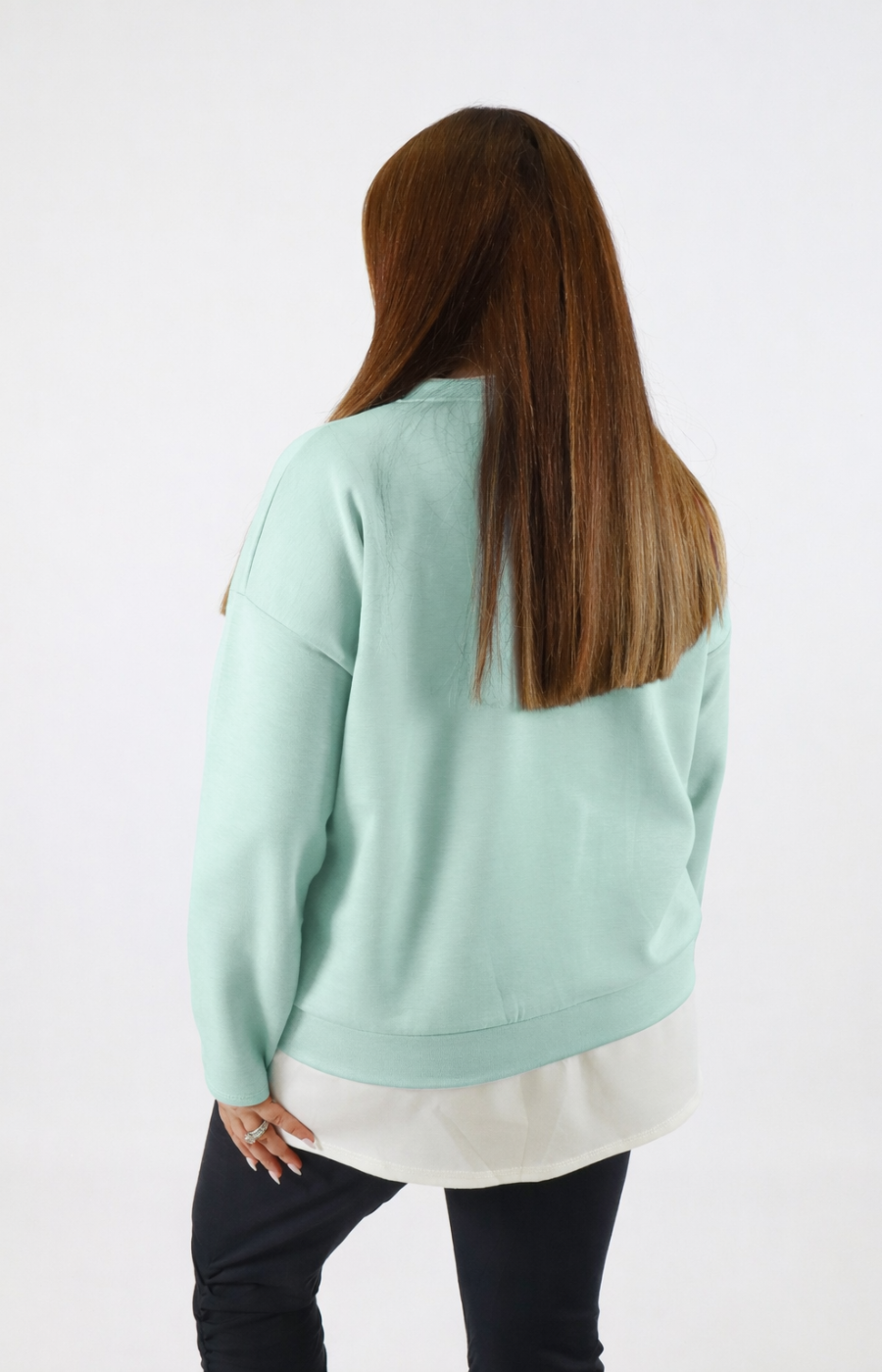 Woman wearing a navy sweatshirt with a white trim on a plain background