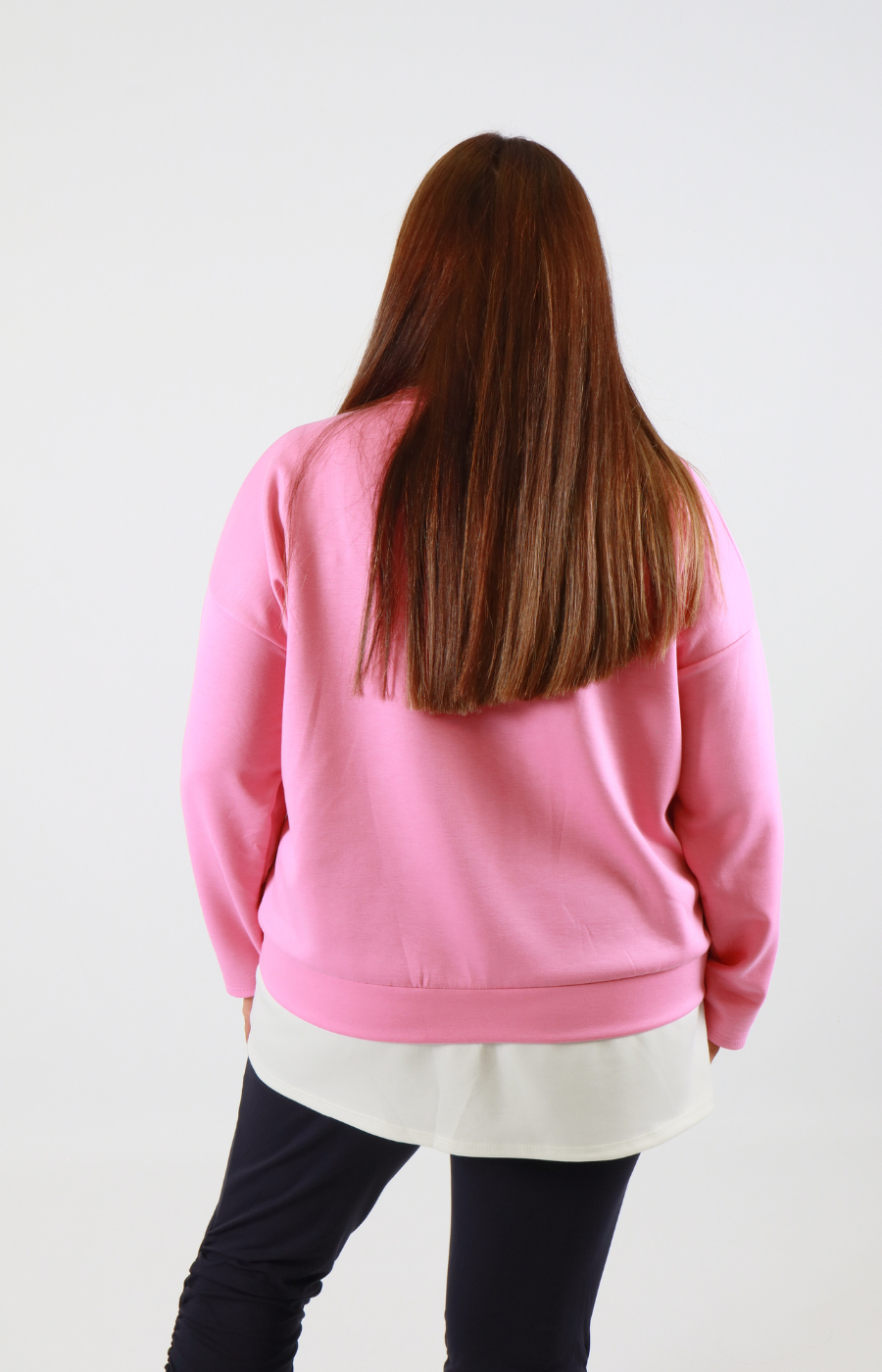 Person wearing a pink sweatshirt with a plain background
