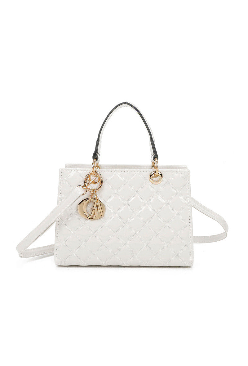 White handbag with gold chain and pendant on a white background