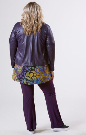 Person wearing a purple leather jacket and pants with a colorful skirt on a white background