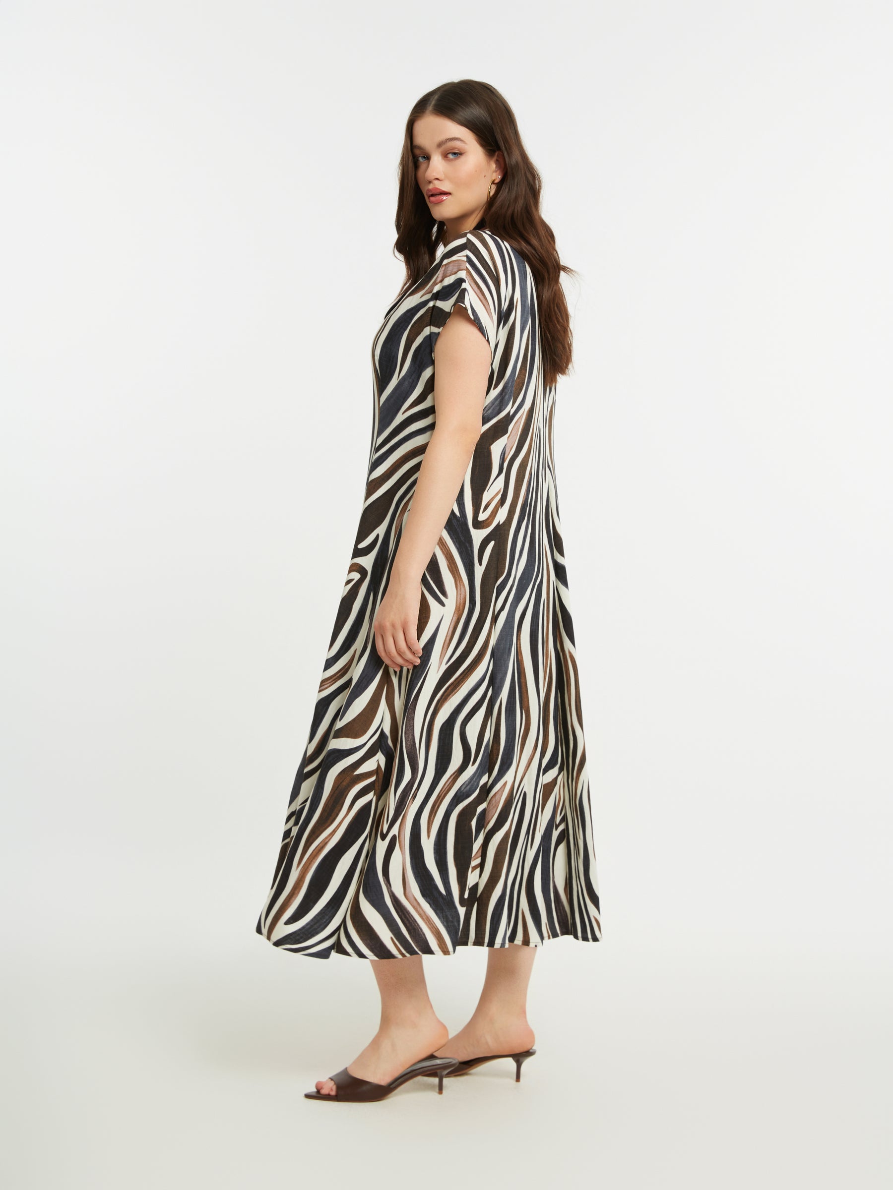 Woman wearing the Mat Animal Print Dress, a zebra print A-line dress on a white background
