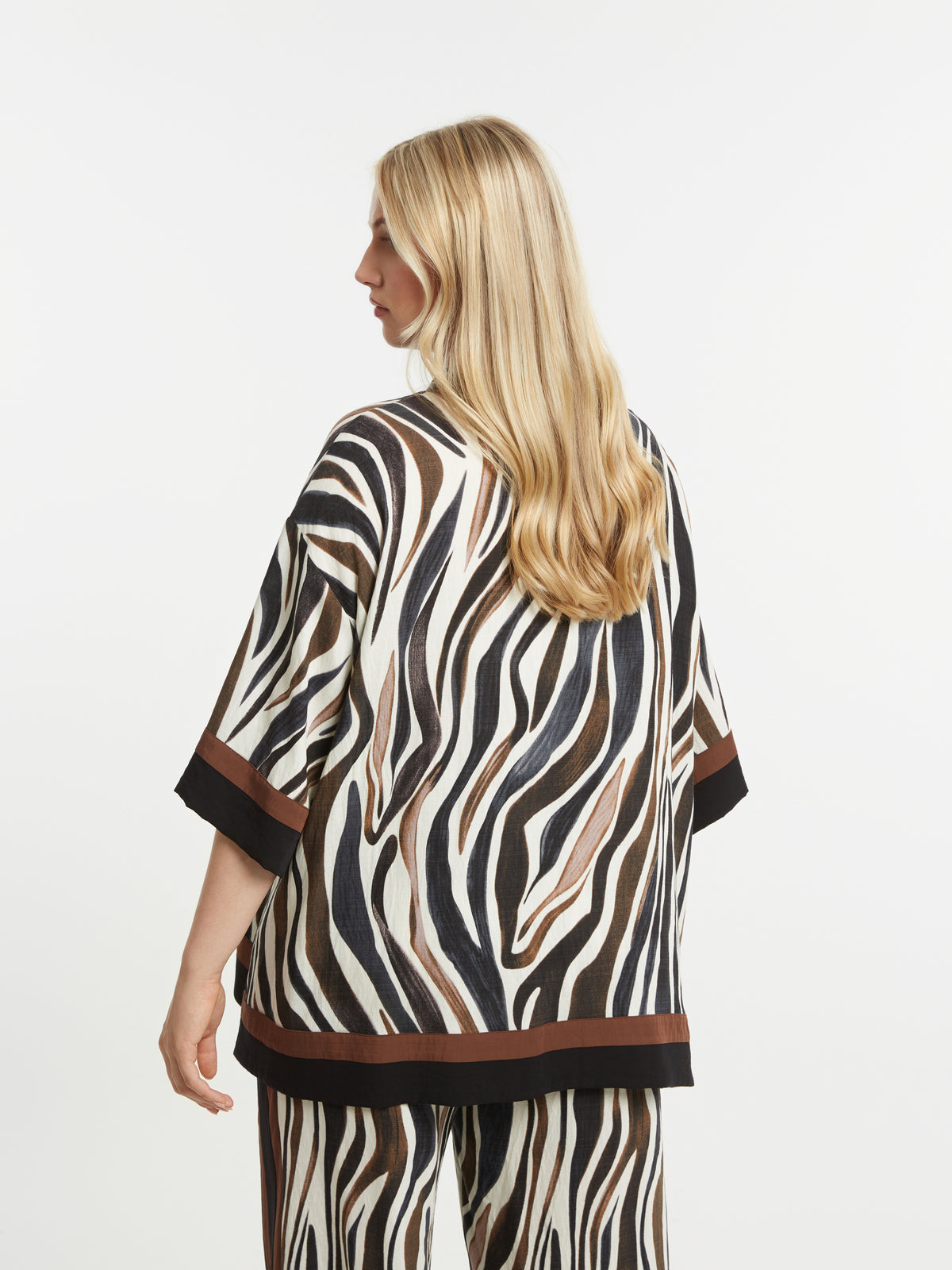 Woman wearing the Mat Animal Print Shirt an oversized shirt with 1/2 length sleeves on a white background