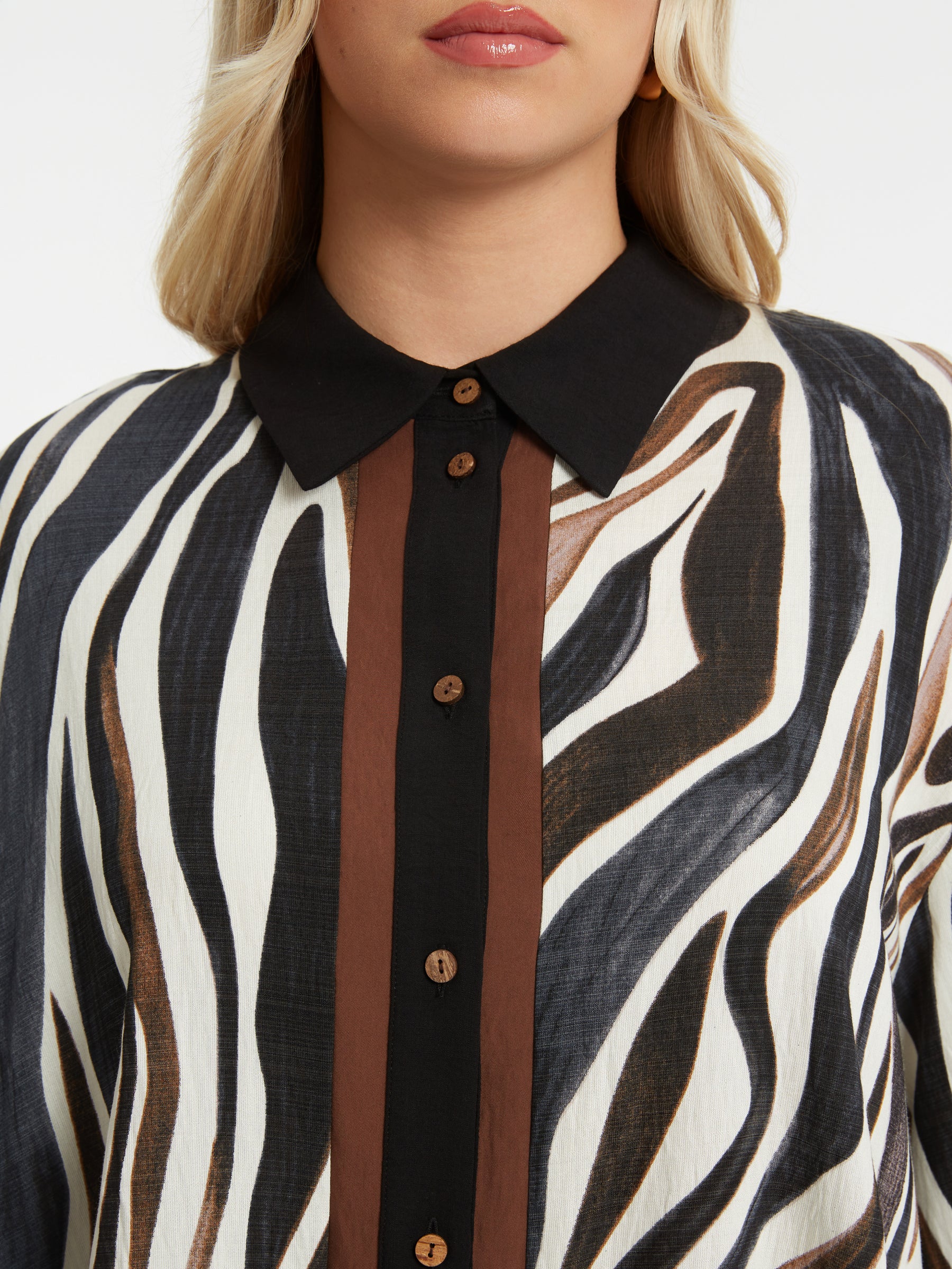 Close-up of the black collar and brown buttons and animal print on the Mat Animal Print Shirt