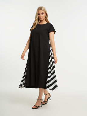 Woman wearing the Mat Black Dress with Side Stripes a black dress with a white and black striped pattern on a white background