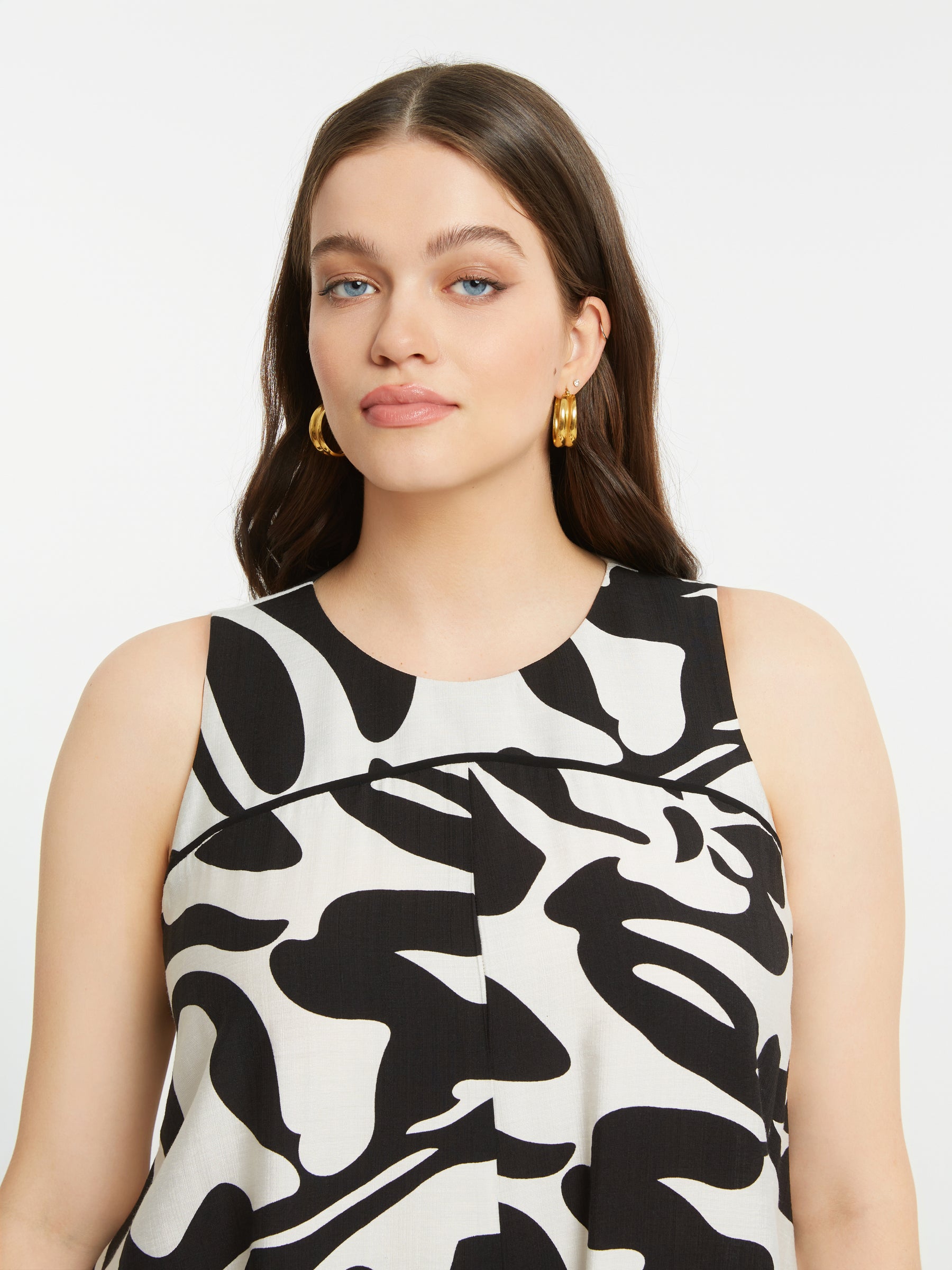 Women wearing the Mat Black and White Swirl Dress, a patterned, sleeveless dress with a round neckline 
