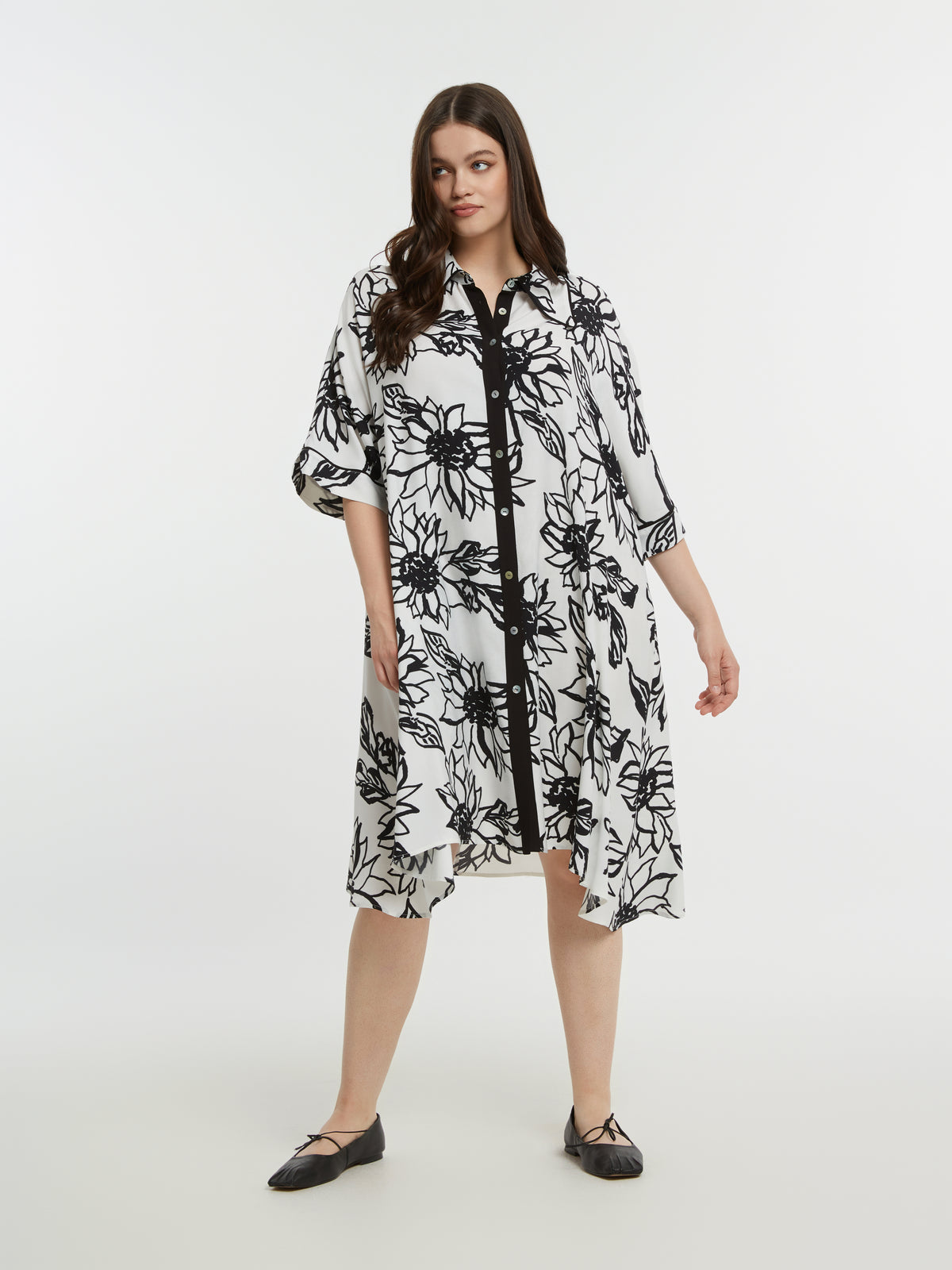 Woman wearing a black and white floral dress on a white background