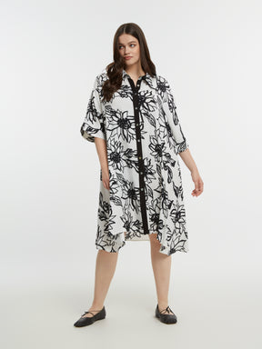 Woman wearing a black and white floral dress on a white background