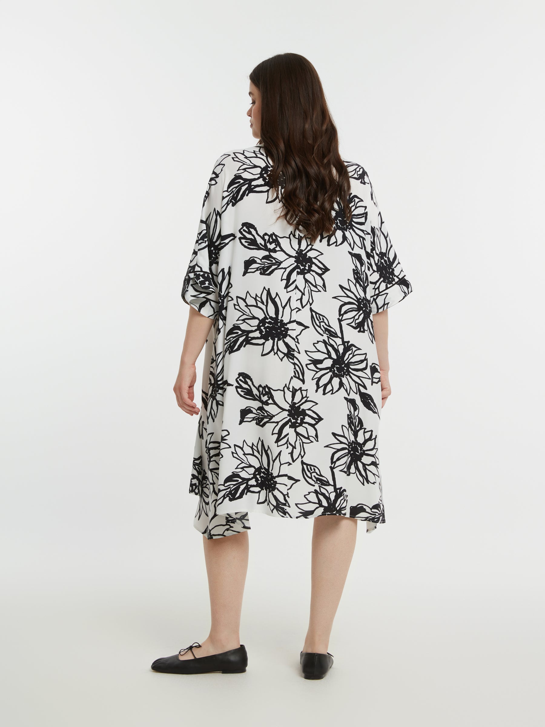 Woman wearing a black floral dress on a white background