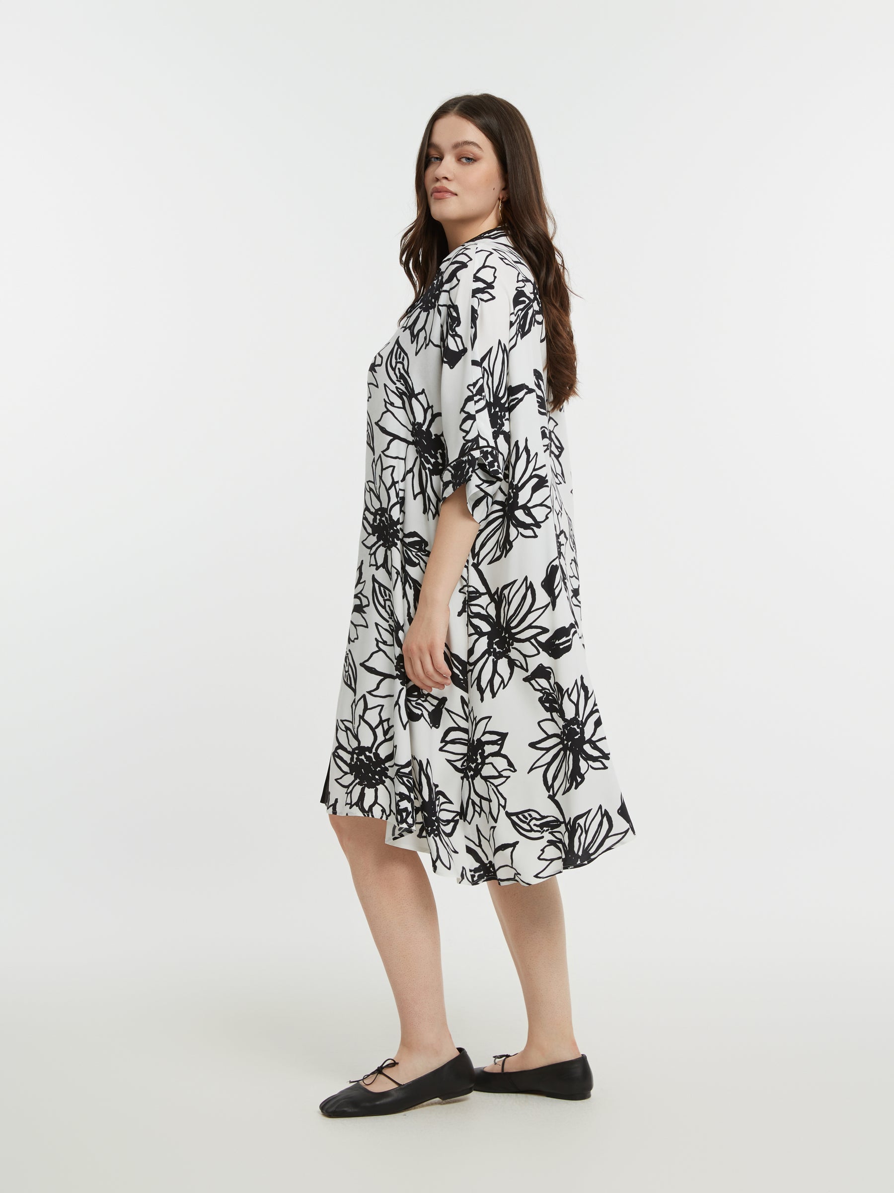 Woman wearing a black and white floral dress on a white background