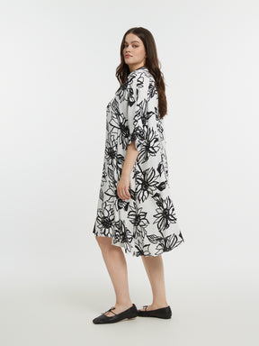 Woman wearing a black and white floral dress on a white background