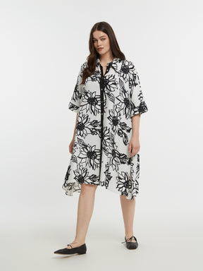 Woman wearing a black and white floral dress on a white background