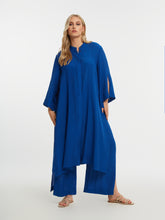 Woman wearing the Mat Longline Tunic in Blue
 with a plain background