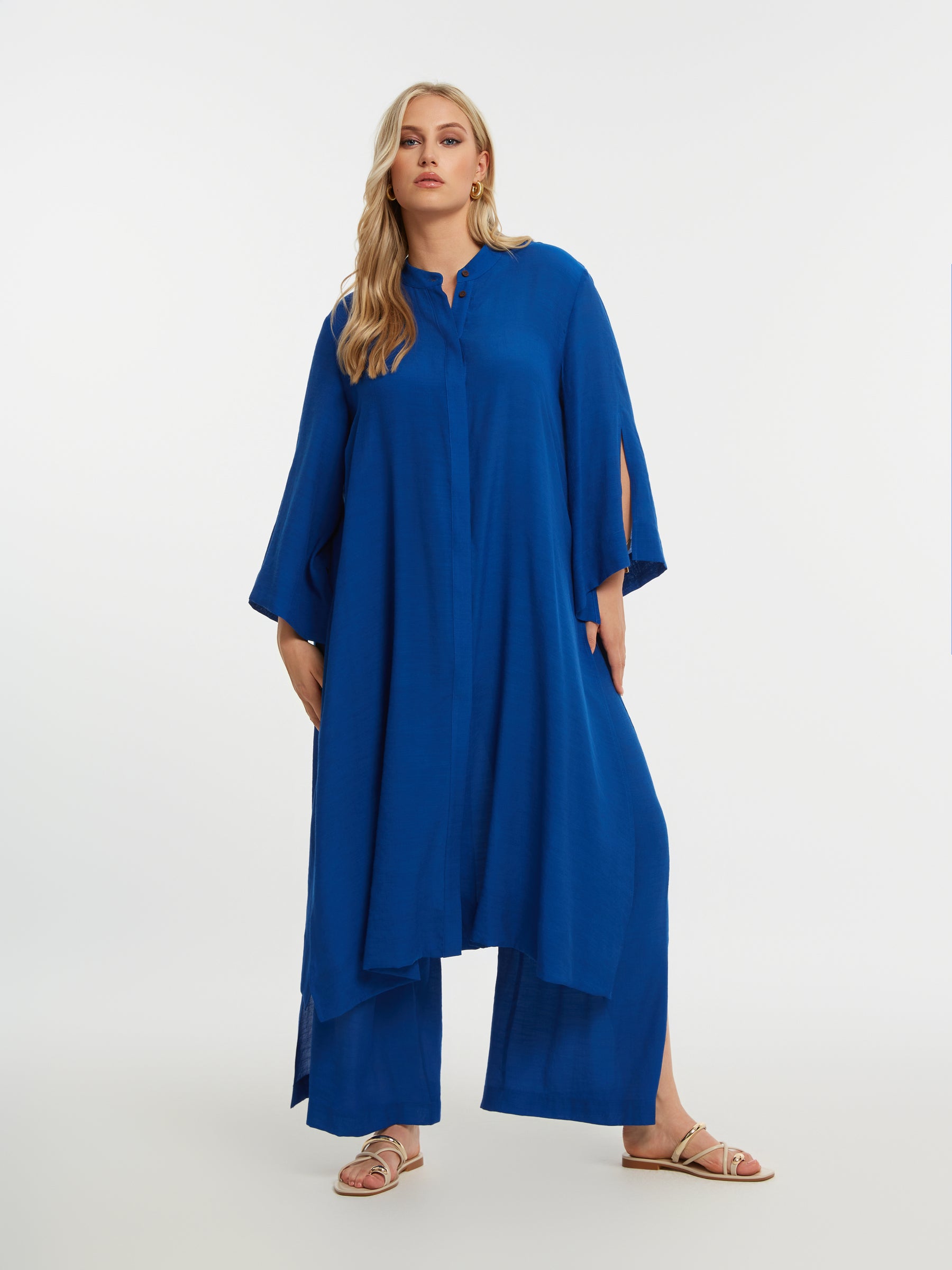 Woman wearing the Mat Longline Tunic in Blue
 with a plain background