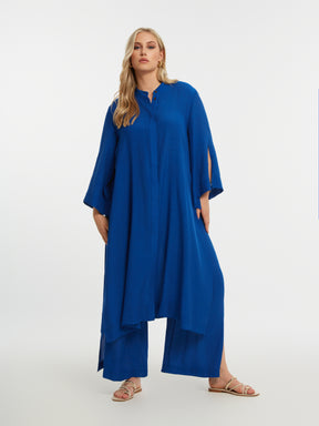Woman wearing the Mat Longline Tunic in Blue
 with a plain background