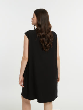 Woman wearing a black sleeveless dress against a white background