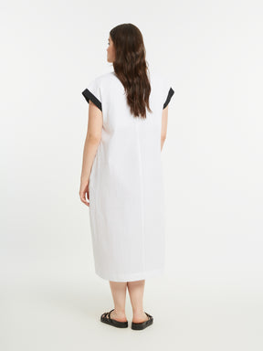 Woman wearing a white dress with black accents on a white background