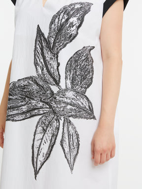 White sleeveless top with black floral design worn by a person