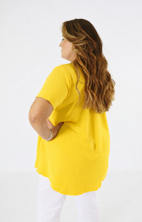 Woman wearing a yellow blouse on a white background
