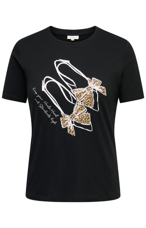 The Only Carmakoma Beau T-Shirt in Black, a black short-sleeve crewneck t-shirt featuring a graphic of two high-heeled shoes embellished with white rhinestones and leopard-print bows, with white script text on the front.