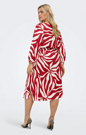 Woman wearing the Only Carmakoma Camille Dress in Red, a red and white zebra print dress with long sleeves and comes to a knee length on a white background