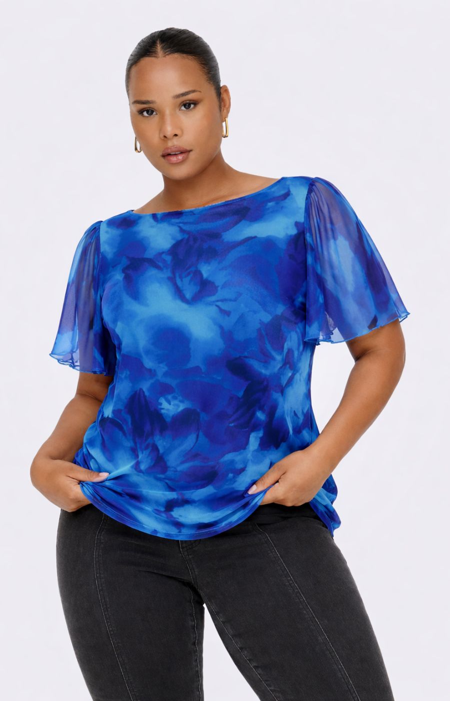 Woman wearing the Only Carmakoma Forest Top in Blue , a blue floral patterned top against a white background