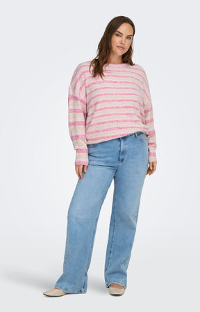 Woman wearing Only Carmakoma Johanna Knit in Pink, a pink and white striped sweater and blue jeans on a white background