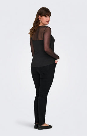 A woman modelling the Only Carmakoma Love Top in Black, a black long-sleeve top with sheer mesh sleeves and a matching black camisole-style front, paired with black pants and flats, shown from the back against a light gray studio background.