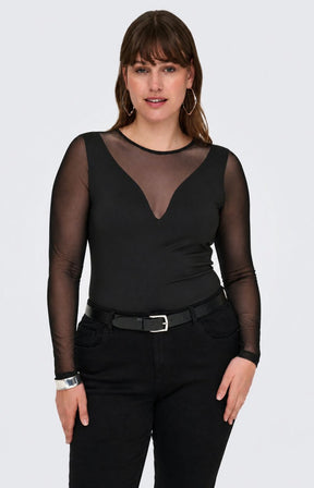 A woman modelling the Only Carmakoma Love Top in Black, a black long-sleeve bodysuit with sheer mesh sleeves and a sheer V-neckline, paired with black pants and a black belt, against a light gray studio background.
