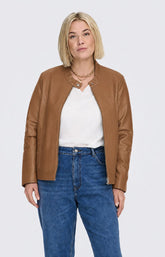 A woman modeling the Only Carmakoma Robber Faux Leather Jacket in Cognac, a cropped tan faux-leather jacket over a white top and blue jeans, standing against a light gray studio background. This image was created using AI.