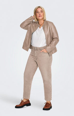 A woman modeling the Only Carmakoma Robber Faux Leather Jacket in Walnut, a light taupe faux-leather jacket with a zippered front, buttoned collar, and side pockets, paired with a white top and matching taupe pants against a light gray background. This image has be created using AI