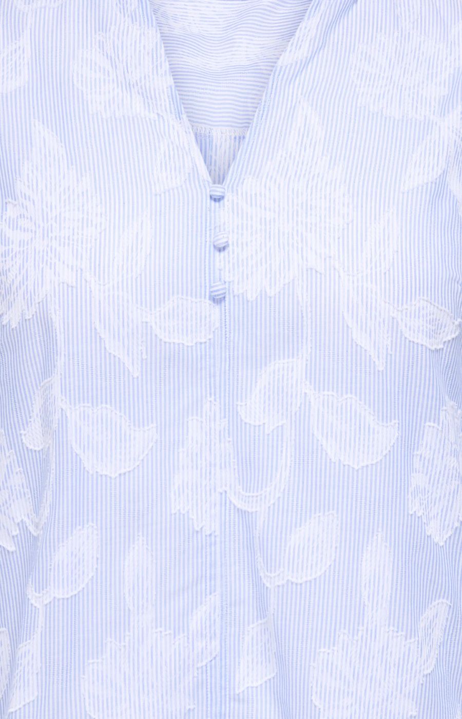 Light blue blouse with white floral pattern on a light blue background