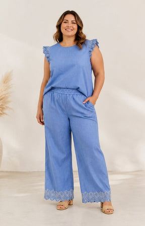Woman wearing a blue outfit with lace details on a white background