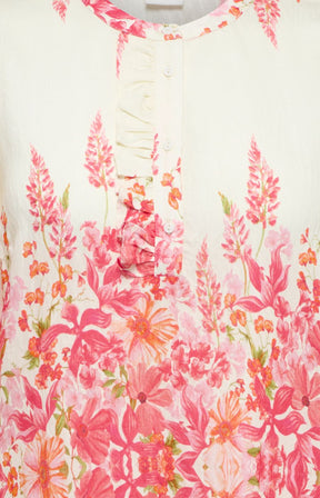Close-up of a floral patterned garment with pink and orange flowers on a white background.