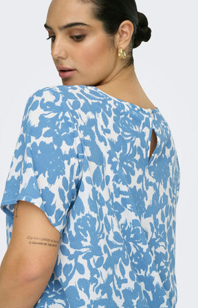 Woman wearing a blue and white floral patterned blouse 