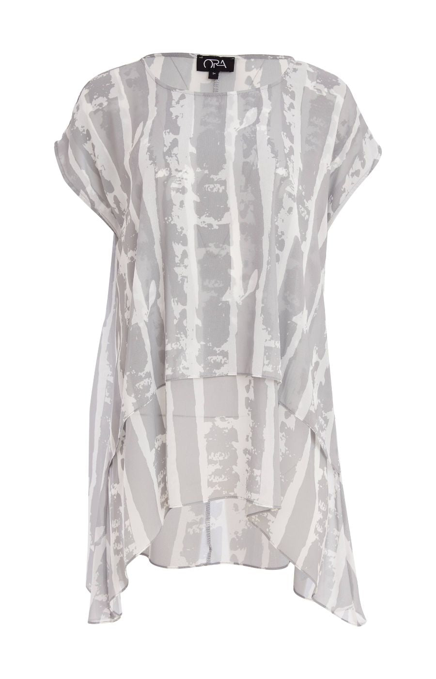 Woman wearing the Ora Layered Top in Grey, a slightly sheer, double layered top with a  light grey and white patterned top. Has a round neckline, short sleeves and a curved hem worn with white trousers against a plain background   