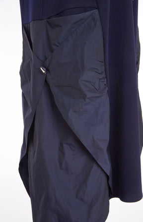Woman wearing the Ora Side Pocket Dress in Navy, a navy blue dress with side pockets, round neckline and short sleeves, in a midi length.  