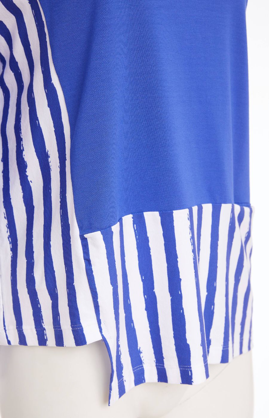 Woman wearing the Ora Striped Pocket Top in Blue, a blue top a round neckline and 3/4 length sleeves with white striped hem against a plain background    