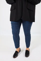 Person wearing black shoes, blue socks, and black pants on a white background