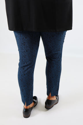 Person wearing blue pants and black shoes on a white background