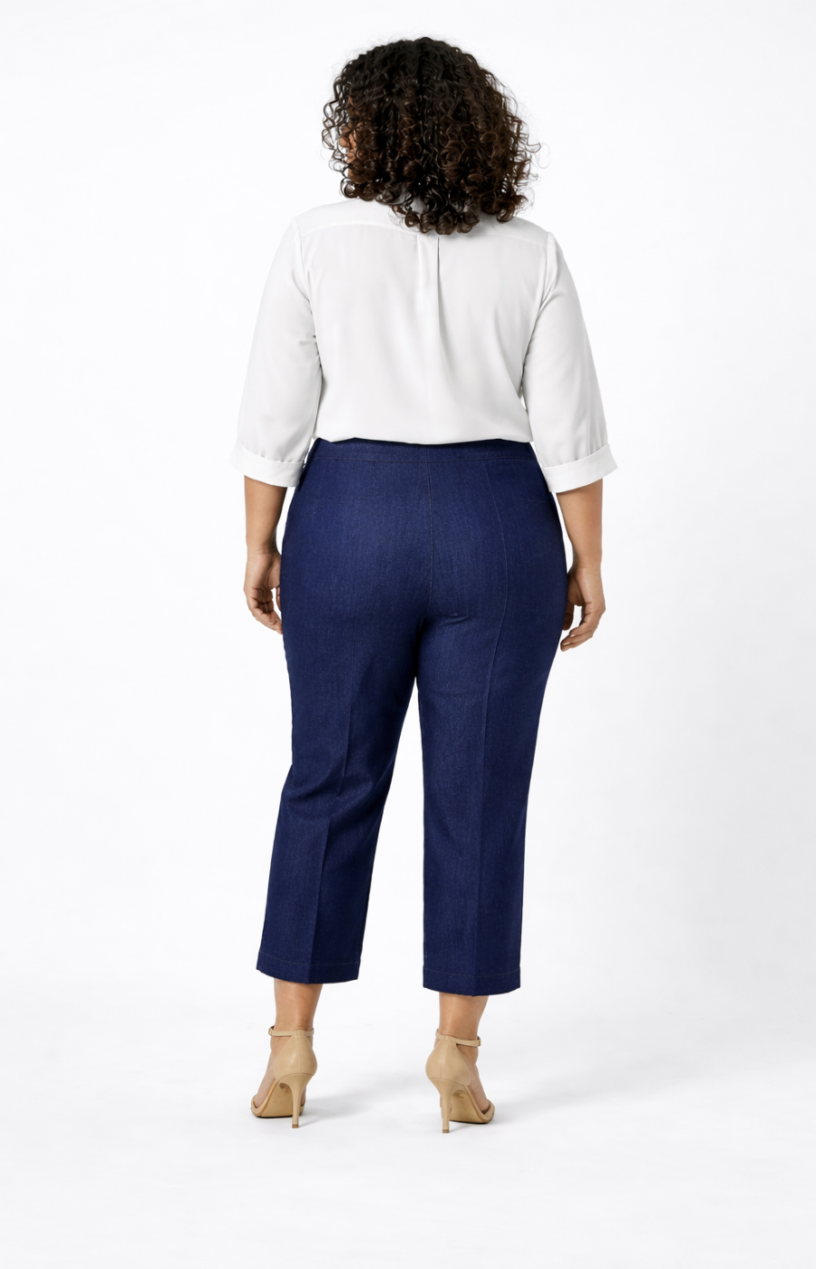 Person wearing a white blouse and navy jeans on a white background