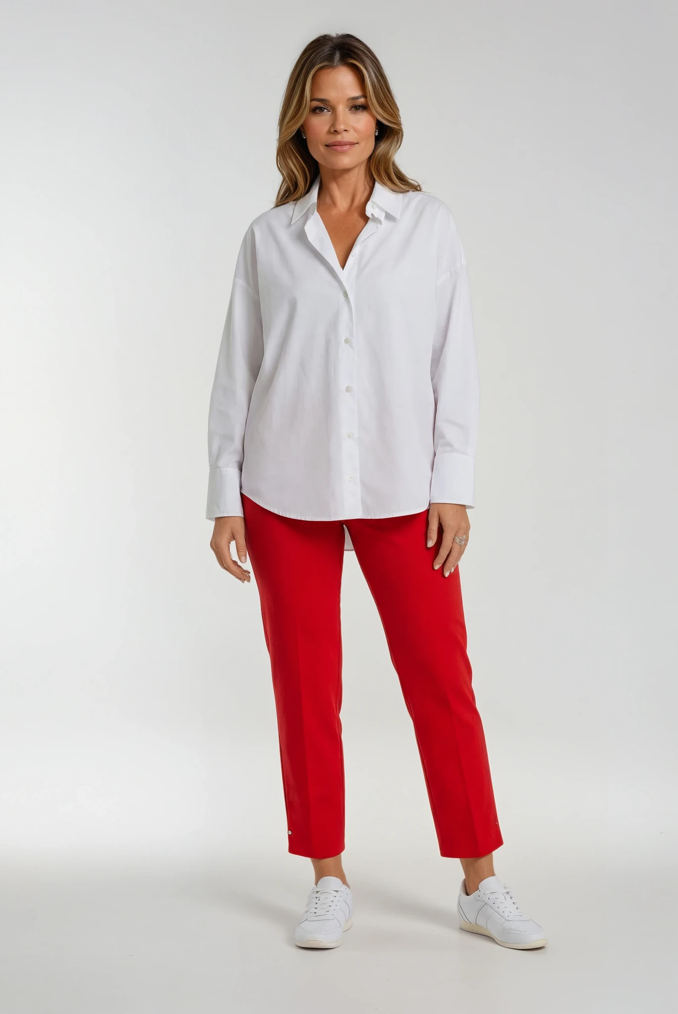 Woman wearing a white shirt and red trousers on a white background