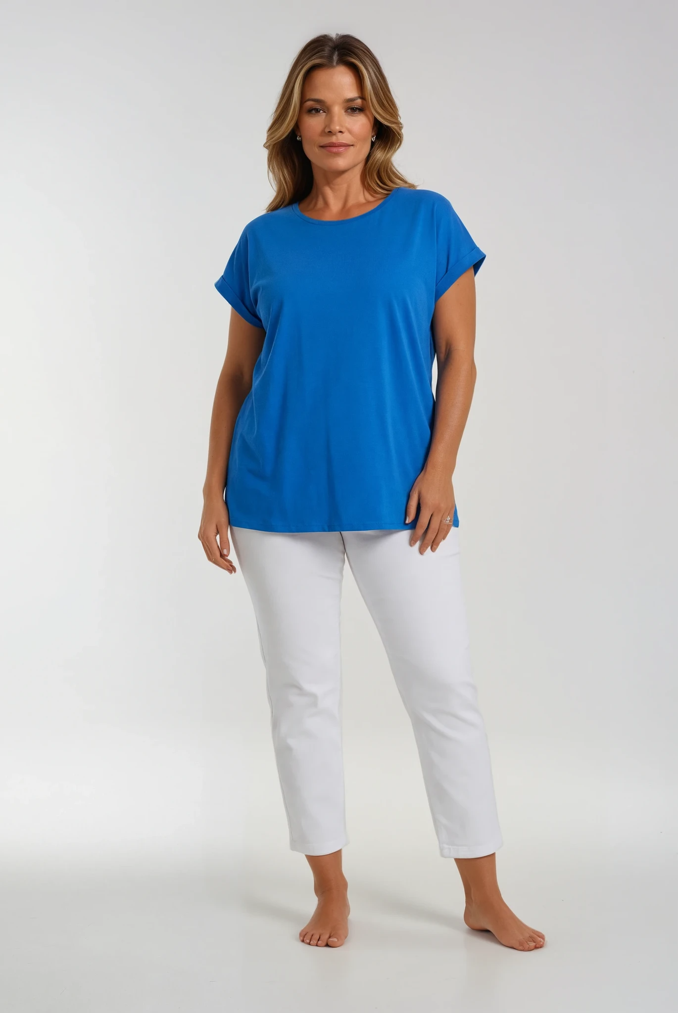 A woman wearing white jeans and a blue t-shirt on a white background