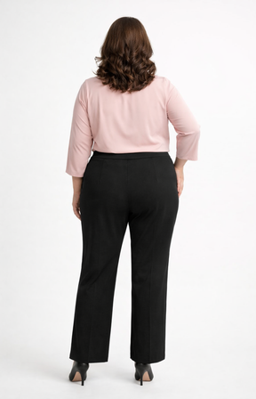Person wearing a light pink top and black trousers on a white background