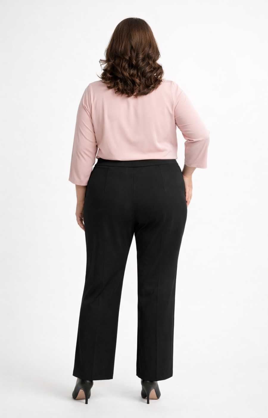 Person wearing a light pink top and black trousers on a white background